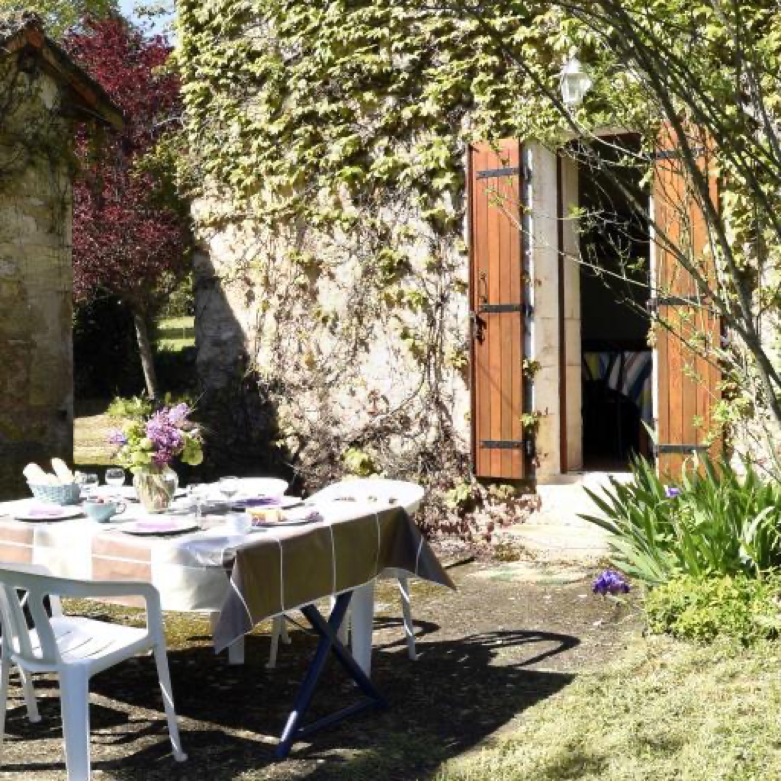 Une terrasse sans vis à vis, donnant sur la cuisine, avec vue sur le jardin et le court de tennis.