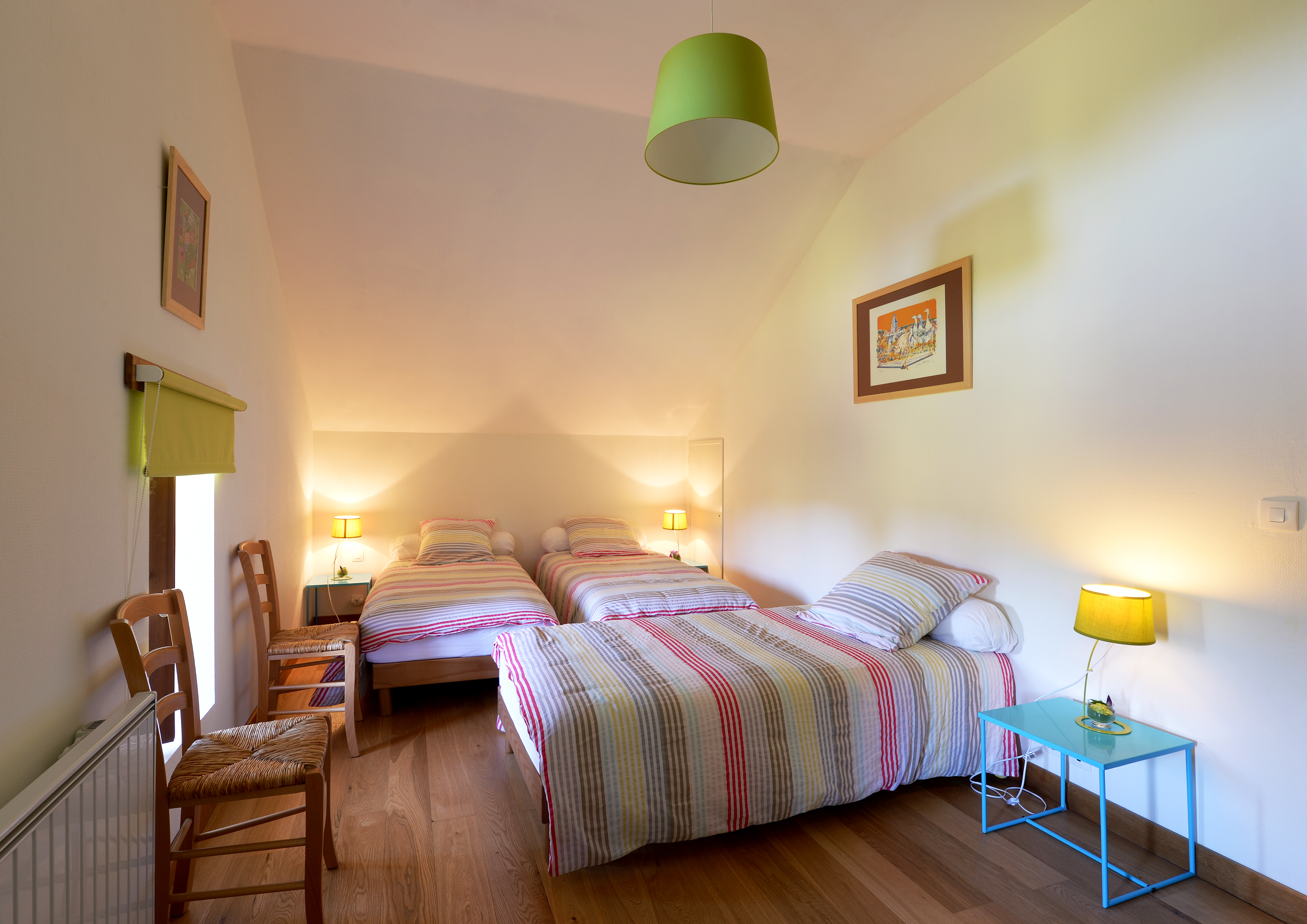 Chambre chaleureuse avec trois lits simples, décoration lumineuse et touches de couleur vive